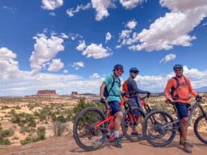 Guests posing with amazing views on Canyonlands, Arches and Moab multi sport mountain bike tour with Escape Adventures
